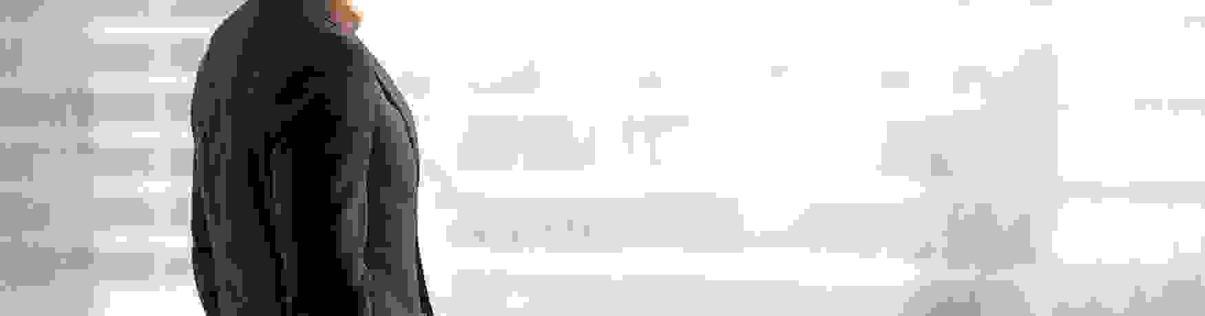 Business man stands looking out out a blurred window with hands in pockets