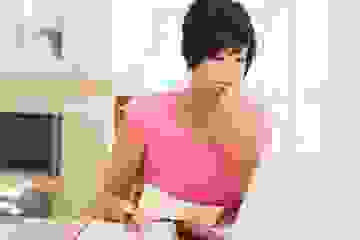 Lady puzzling over a computer screen with receipts