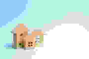 Three wooden house models on a blue background