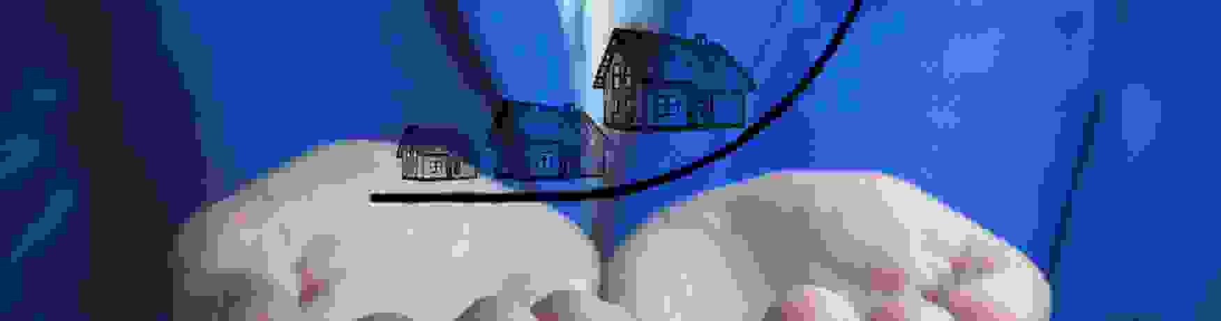 Concept image for rising house prices with man in blue suit holding a graphic image in his hands