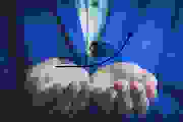 Concept image for rising house prices with man in blue suit holding a graphic image in his hands