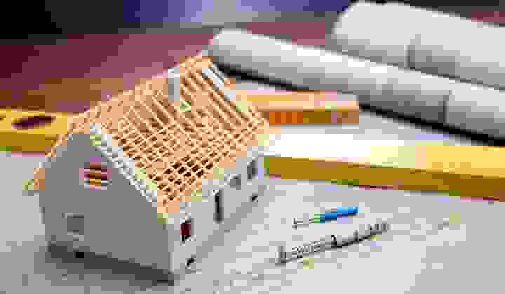 Architectural plans, model house, ruler and screws