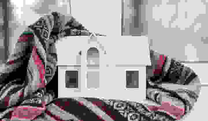 House model wrapped in a plaid scarf on a white windowsill