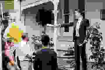 An auctioneer calls out a bid at an onsite real estate auction with a group of buyers gathered
