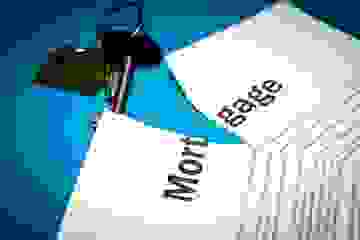 Photo of a torn mortgage contract with house keys