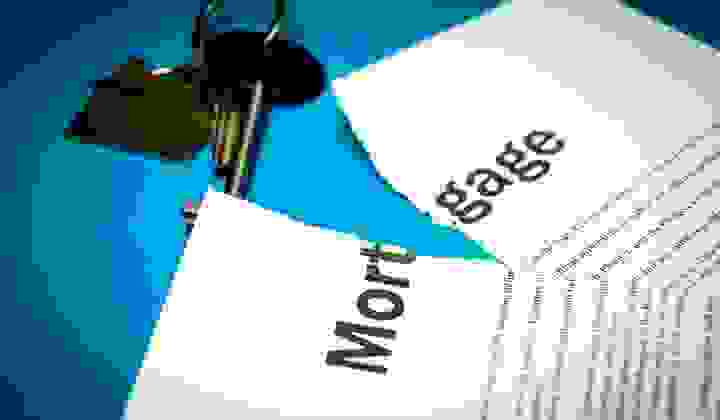 Photo of a torn mortgage contract with house keys