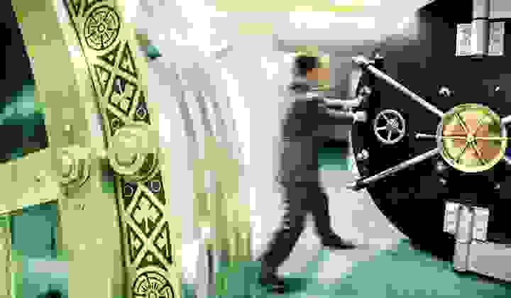 Banker opening a safe door