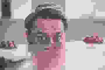 Nervous man peering over the edge of a wooden desk