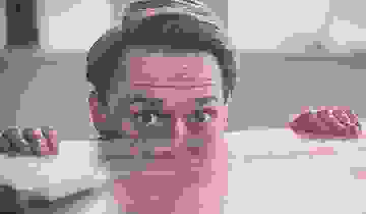 Nervous man peering over the edge of a wooden desk