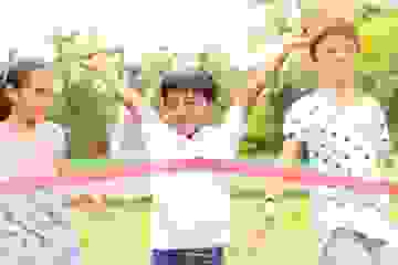 Young boy winning a race with two friends behind him