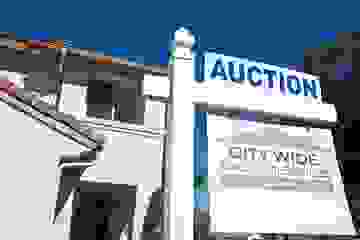 Large house with auction sign out the front