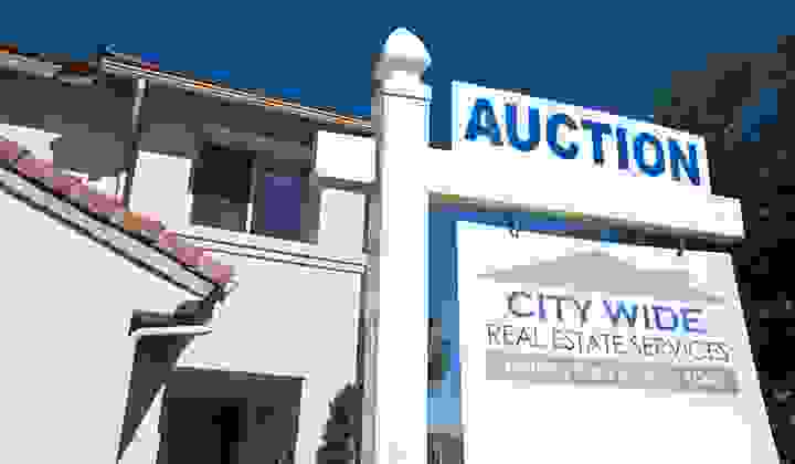 Large house with auction sign out the front