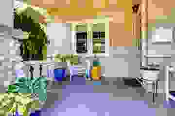 Welcoming front entrance to a house with plants and a wicker chair with cushions