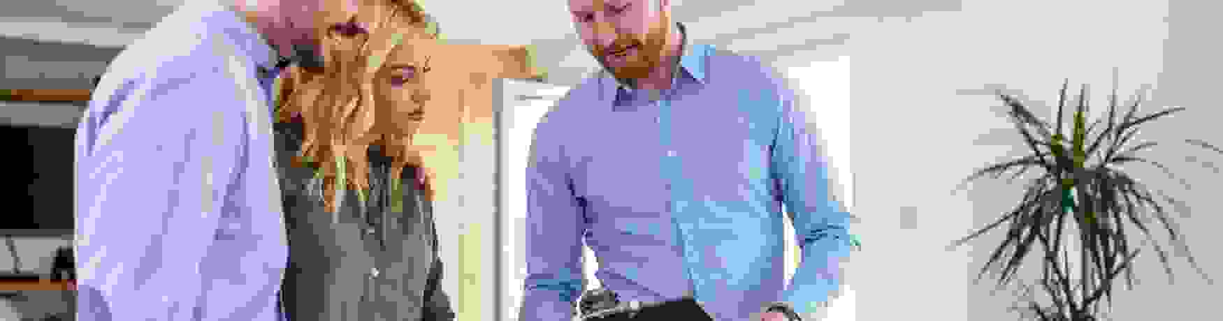 A property manager runs a young couple through a checklist at a new rental house