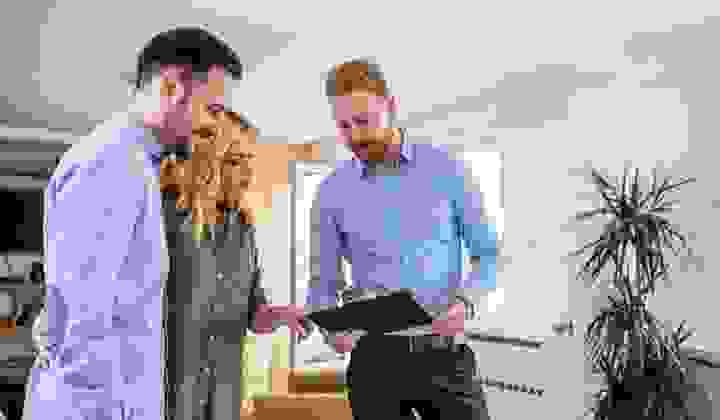 A property manager runs a young couple through a checklist at a new rental house