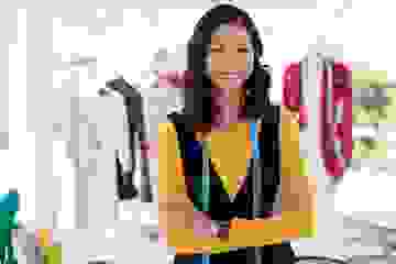 Self employed fashion designer smiling at the camera with arms crossed