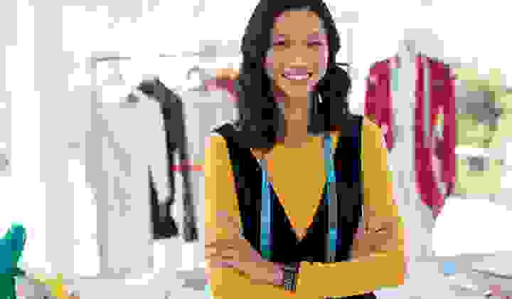 Self employed fashion designer smiling at the camera with arms crossed