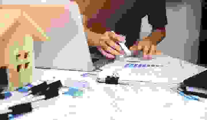 Soft focus shot of a man at his desk with laptop open and financial paperwork in front of him