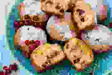 Freshly baked berry muffins on a plate with fresh berries as a garnish