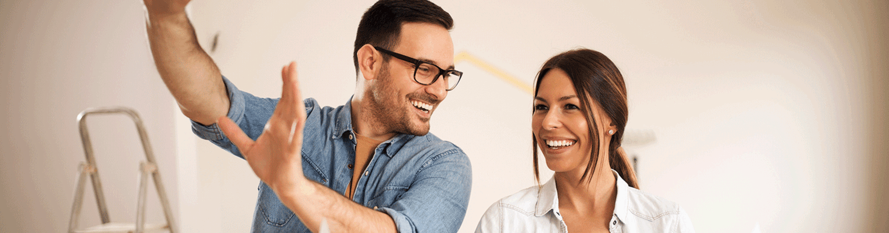 Smiling couple in a house that needs renovating discussing plans