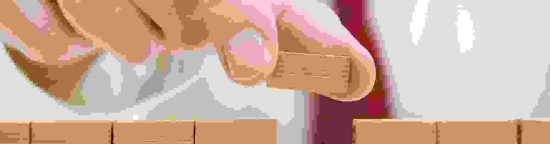 Close up as a man puts the last little brick in a miniature wall