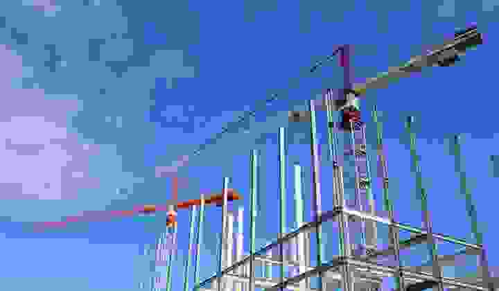 Cranes on a construction site against a bright blue sky