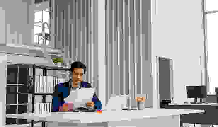 Asian businessman reading over documents in a large modern office