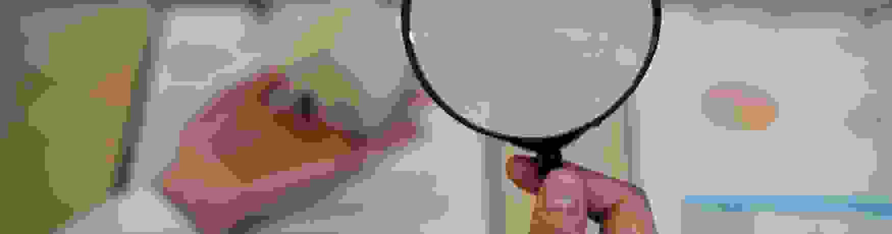 Woman looking at mortgage loan documents through a magnifying glass