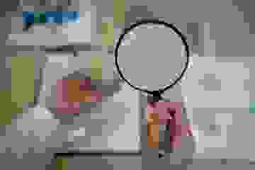 Woman looking at mortgage loan documents through a magnifying glass