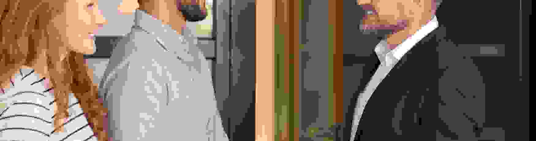 Young couple shaking hands with a property manager outside a house