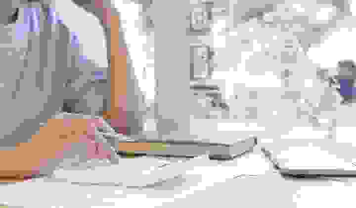 Woman at a desk with a calculator and laptop